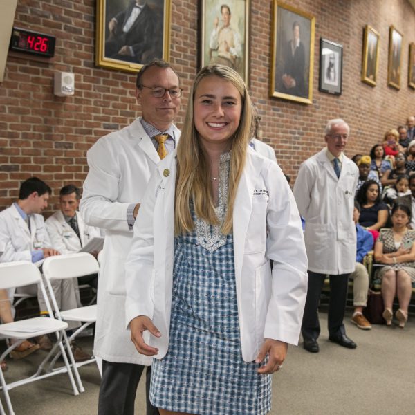 A woman puts on a white coat